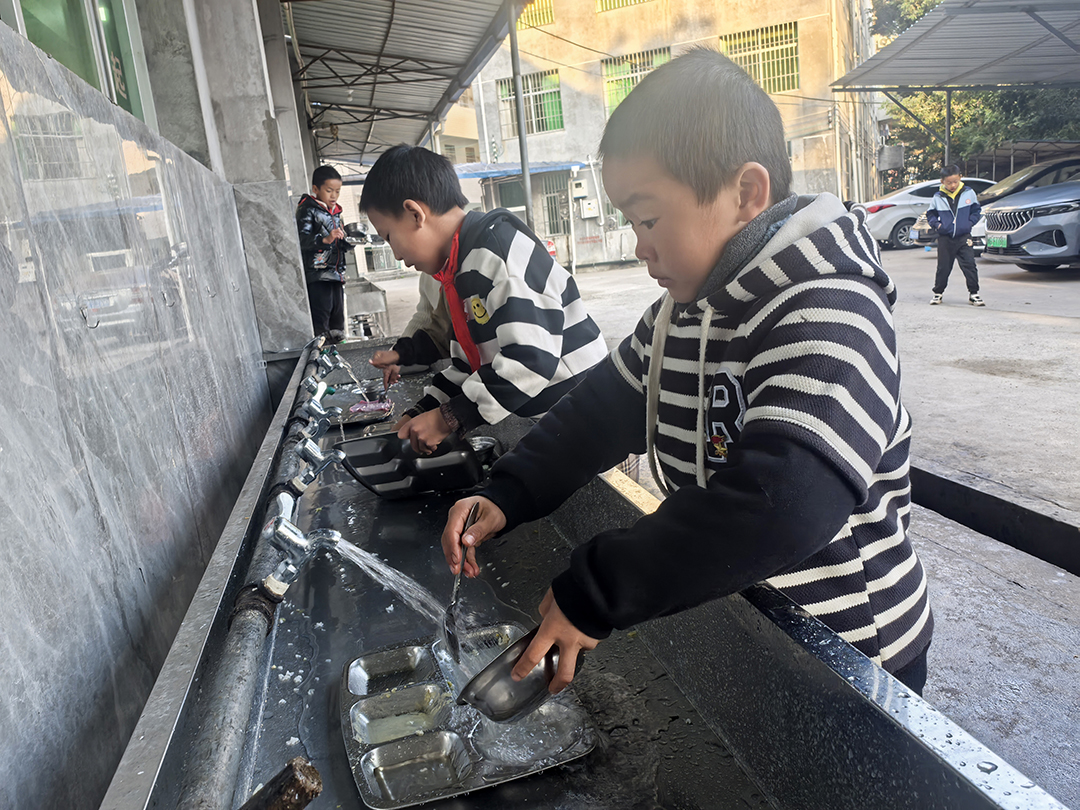 梅山中心小学部分学生正在排队用水